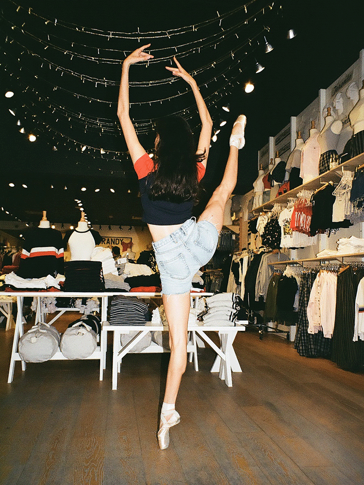 A ballerina dancing in a store on pointe. Shot on 35mm film. 