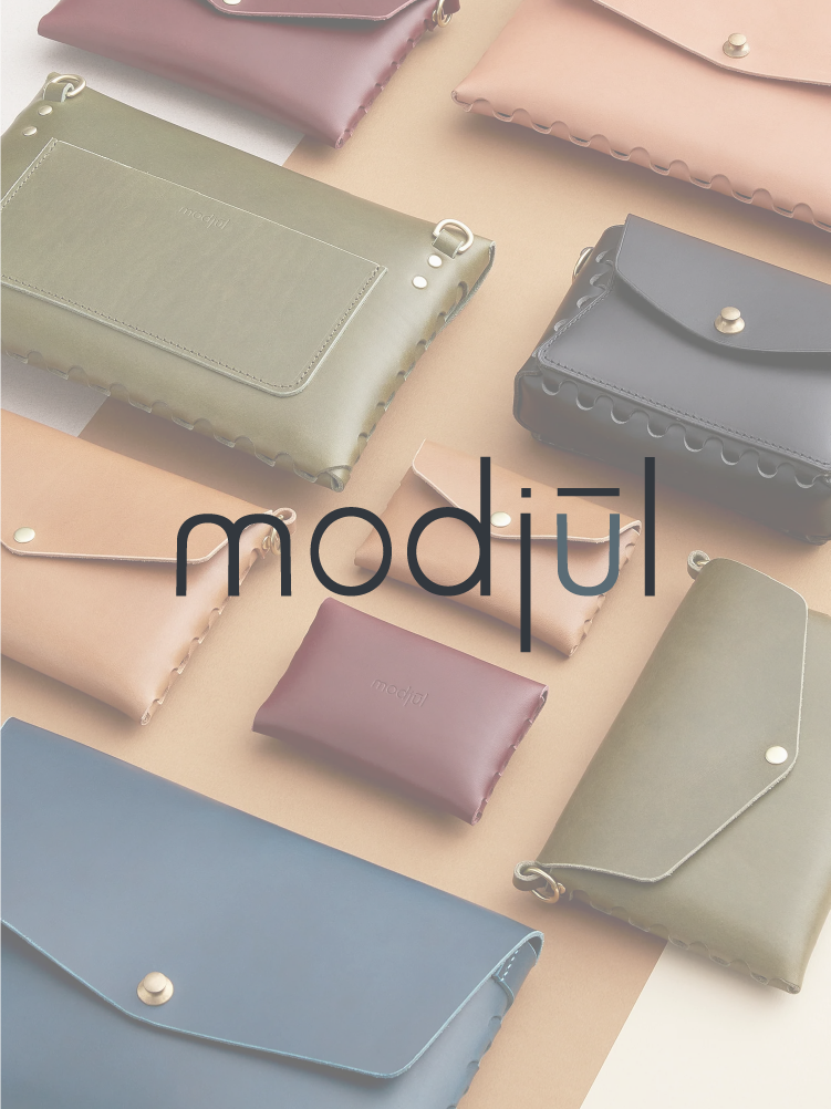 The modjūl logo overlaid on top of a photo of modjūl bags.